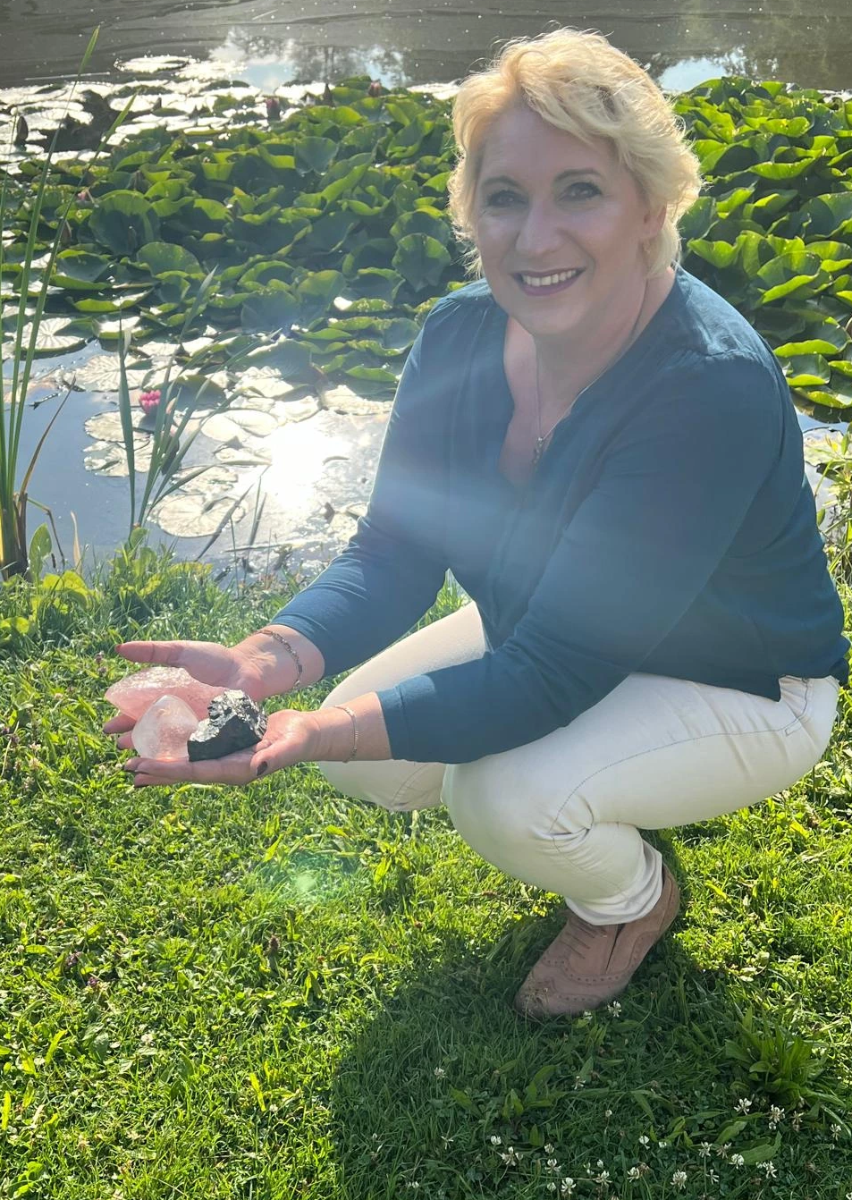 Josefine V.D. Kramer - kniet am See. In den Händen hält sie Kristalle Josefine V.D. Kramer - kniet am See. In den Händen hält sie Kristalle
